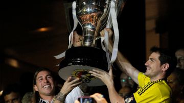 Los jugadores Sergio Ramos (izq.) e Iker Casillas levantan el trofeo de campeones de  la liga española 2011-2012  obtenido por el Real Madrid.