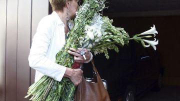 Una mujer lleva flores a la casa del mexicano Carlos Fuentes donde serán velados los restos del escritor.