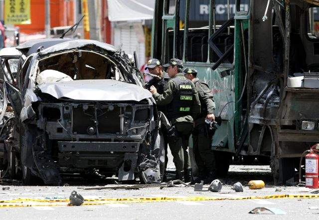Policías llegan al lugar donde la explosión de una bomba en el interior de un autobús causó la muerte a al menos cinco personas.