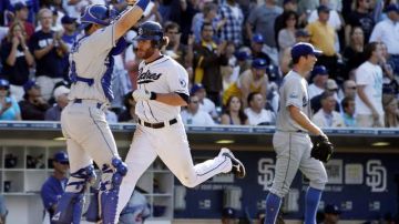 Chris Denorfia anota por los Padres  en el sexto inning del juego de ayer ante la mirada del catcher de los Dodgers,  Matt Treanor.