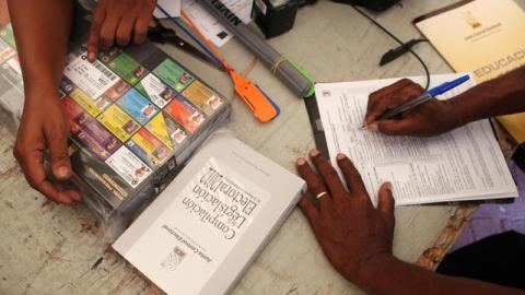 Miembros de un colegio electoral dominicano revisan un paquete con votos en la sede la Junta Central Electoral del Distrito Nacional en Santo Domingo.
