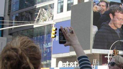 El fundadorde Facebook, Mark Zuckerberg (en la pantalla), hizo sonar hoy la campana con la que se da comienzo a la sesión en el mercado Nasdaq.