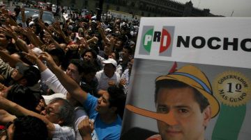 Un cartel exhibido durante la marcha muestra a Peña Nieto con una nariz de Pinocho.