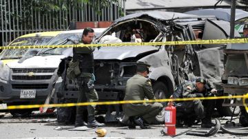 Policías colombianos inspeccionan el sitio donde explotó una bomba el martes; fue colocada en el exterior de un auto.