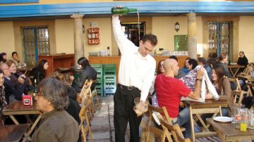 Un camarero vierte sidra a los comensales en Oviedo, España.