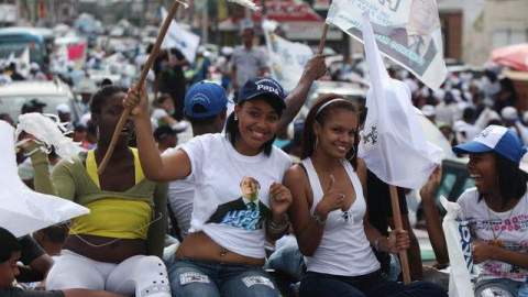 (Arriba) seguidores del candidato presidencial Danilo Medina del PLD durante el cierre de campaña al igual que manifestantes del opositor Partido PRD, Hipólito Mejía (fuera de cuadro), quienes concluyeron el viernes los desfiles políticos.