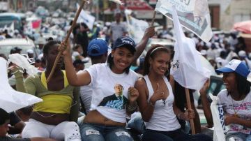 (Arriba) seguidores del candidato presidencial Danilo Medina del PLD durante el cierre de campaña al igual que manifestantes  del opositor Partido PRD, Hipólito Mejía (fuera de cuadro), quienes concluyeron el viernes los desfiles políticos.