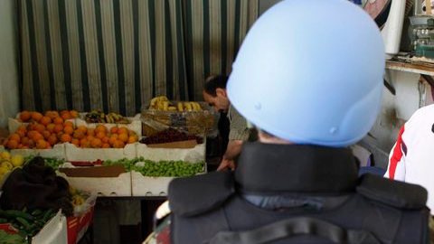 Un observador de ONU en Siria habla con un empleado de una tienda, en  Damasco, Siria,