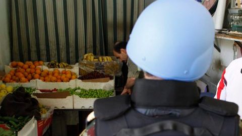 Un observador de ONU en Siria habla con un empleado de una tienda, en  Damasco, Siria,