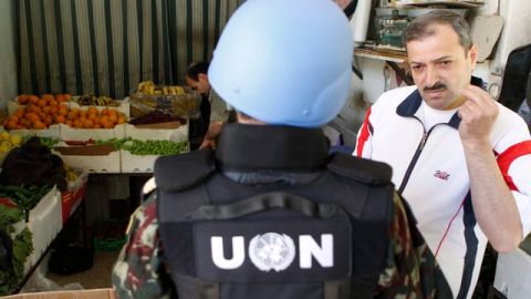 Un observador de ONU en Siria habla con un empleado de una tienda, en  Damasco, Siria,