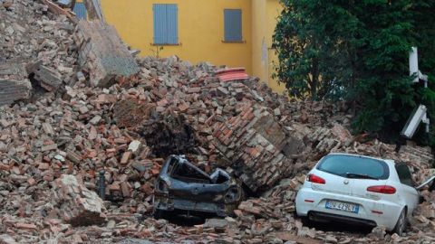 Varios coches enterrados por los escombros de un edificio destruído en Finale Emilia, Módena, Italia, tras el terremoto  ayer.