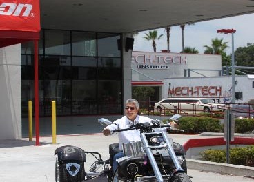 Edwin Colón, presidente y CEO de Mech-Tech, montado en un triciclo.