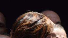 Cándida Montilla, esposa del presidente electo de República Dominicana, Danilo Medina, le seca el sudor del cuello mientras este ofrece su primer discurso.