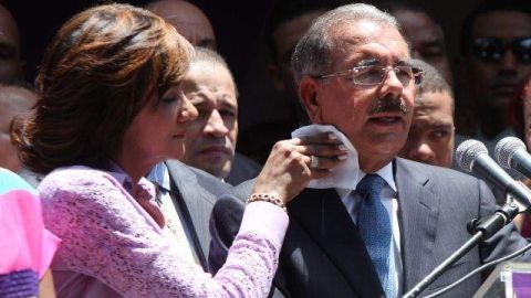 Cándida Montilla, esposa del presidente electo de República Dominicana, Danilo Medina, le seca el sudor del cuello mientras este ofrece su primer discurso.