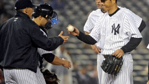 El japonés Hiroki Kuroda (der.) le entrega la bola al piloto Joe Girardi después de ser castigado por los Reales en el sexto episodio.