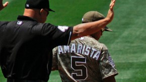 Vernon Wells (der.) se autoexamina la mano tras su lesión. El segunda base de San Diego, Alexi Amarista, le observa.