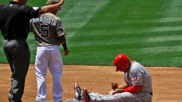 Vernon Wells (der.) se autoexamina la mano tras su lesión. El segunda base de San Diego, Alexi Amarista, le observa.