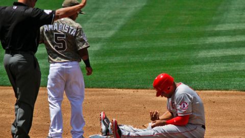 Vernon Wells (der.) se autoexamina la mano tras su lesión. El segunda base de San Diego, Alexi Amarista, le observa.
