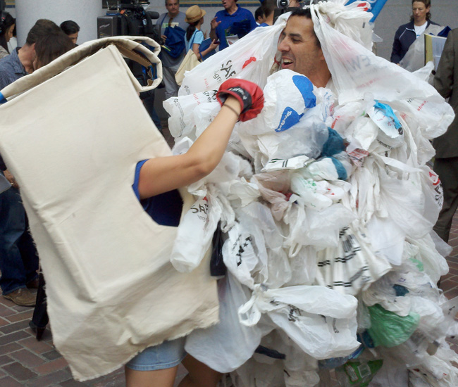 Activistas hacen una parodia sobre la batalla perdida de las bolsas de plastico contra las bolsas reciclables.