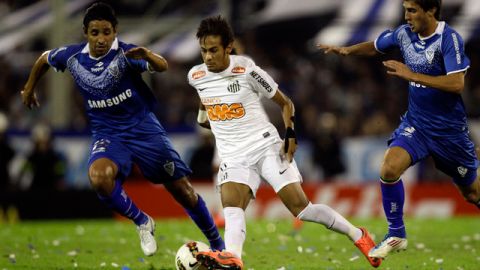 Neymar, del Santos, trata de llevarse el balón ante la marca de los jugadores de Gino Peruzzi (izq) y Víctor Zapata, de Vélez Sarsfield's la semana pasada.