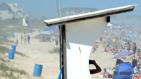 Se ve una multitud de personas en una de las playas de Wilmington, Carolina del Norte, cuando se alzaron las banderas rojas,  de advertencia de riesgo por tormenta tropical.