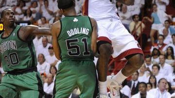 El jugador de los Heat LeBron James (d) disputa el balón con Kevin Dooling (c) de los Celtics durante el primer juego de la final de la Conferencia Este de la NBA.