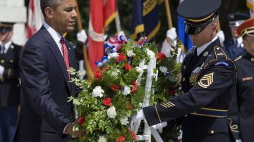 El presidente  Obama (izq.) coloca un arreglo floral en el cementerio militar de Arlington,  Virginia.