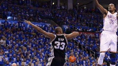 El jugador de los Thunder Kevin Durant (d) salta para encestar ante la marca de Boris Diaw (i) de los Spurs.