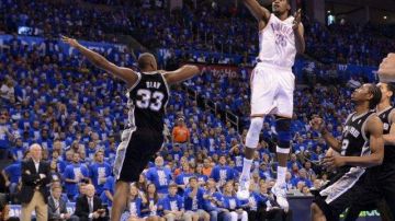 El jugador de los Thunder Kevin Durant (d) salta para encestar ante la marca de Boris Diaw (i) de los Spurs.