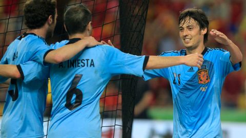 El español David Silva (der.) es felicitado después de lograr derribar la 'muralla china' a cuatro minutos del final del partido amistoso de ayer en Sevilla.