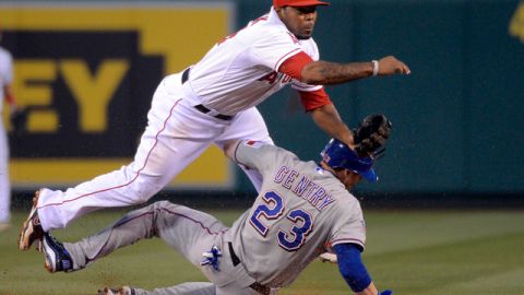 Howard Kendrick (izq.) elimina en segunda a Craig Gentry, de Texas, y dispara a la inicial al inicio de un double play en el tercer inning.