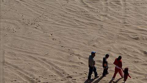 Una familia de inmigrantes camina por el desierto que separa México y Estados Unidos.