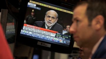 Un corredor de la Bolsa de NY escucha atentamente la alocución de Bernanke, el líder del Banco de la Reserva Federal.
