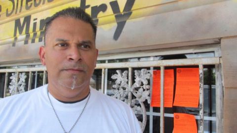 El pastor Roland Nava, al lado de las tres advertencias que el Municipio puso en su ministerio.