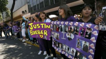 Fans de Justin Bieber portan pancartas mientras esperan para disfrutar del concierto en México.