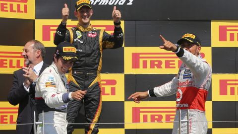 El piloto británico de la Escudería McLaren Mercedes, Lewis Hamilton (der.), el francés Romain Grosjean, de Lotus, y el mexicano Sergio Pérez (izq.), de Sauber, celebran enel podio de Montreal.