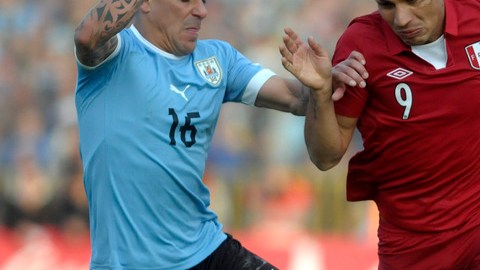 Maximiliano Pereira, de Uruguay, intenta despojar del balón al peruano Paolo Guerrero (9) en el juego celebrado en el Estadio Centenario.