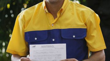 El opositor candidato presidencial, Henrique Capriles, muestra el certificado de registración en la sede del CNE, en Caracas.