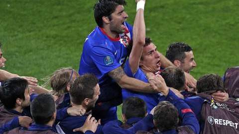 Mario Mandzukic, 'enterrado' por sus compañeros, festeja con el puño en alto después de anotar ayer el 3-1 y su segundo gol sobre Irlanda. Croacia se inyectó optimismo para su partido del jueves contra  Italia.