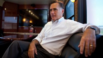 El candidato presidencial Mitt Romney habla con personas de su equipo  en el bus.