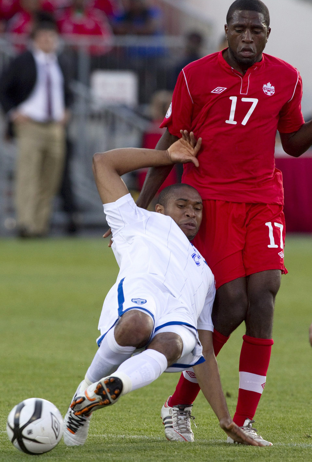 Wilson Palacios (izq.), sostiene un duelo por el balón con el canadiense Olivier Occean durante el partido  de ayer en Toronto.