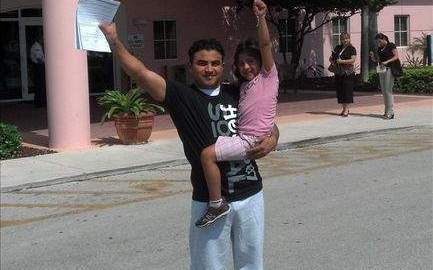 El guatemalteco indocumentado Marvin Corado alzando el brazo junto a su hija Madelyne.