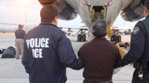 Personal del ICE conduce a un hombre deportado.