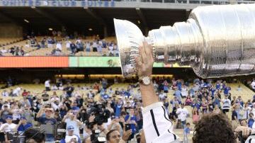 Justin Williams, de Los Angeles Kings, los campeones de la Copa Stanley de hockey sobre el hielo, sostiene el trofeo de campeones durante la ceremonia de inicio del juego entre Angelinos y Dodgers, el 13 de junio de 2012.