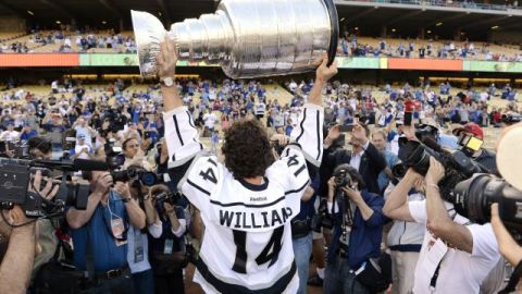 Justin Williams, de Los Angeles Kings, los campeones de la Copa Stanley de hockey sobre el hielo, sostiene el trofeo de campeones durante la ceremonia de inicio del juego entre Angelinos y Dodgers, el 13 de junio de 2012.
