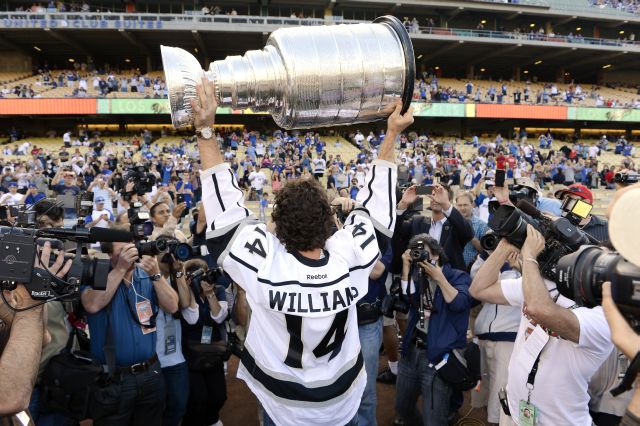 Justin Williams, de Los Angeles Kings, los campeones de la Copa Stanley de hockey sobre el hielo, sostiene el trofeo de campeones durante la ceremonia de inicio del juego entre Angelinos y Dodgers, el 13 de junio de 2012.