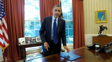 El presidente Barack Obama de pie, frente a su escritorio, en la Oficina Oval de la Casa Blanca tras la firma de una ley.