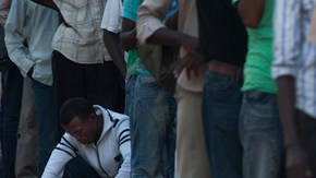 Trabajadores africanos que emigraron rumbo a Israel hacen fila en Tel Aviv, donde esperan que se les provea  alimento.