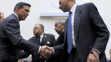 Darryl Issa, (i), y  Eric Holder se dan un apretón de manos en el Capitolio Federal.