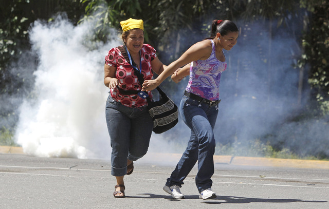 Familiares de reos de El Rodeo I huyen de gases lacrimógenos lanzados por Guardia Nacional venezolana, un año atrás.